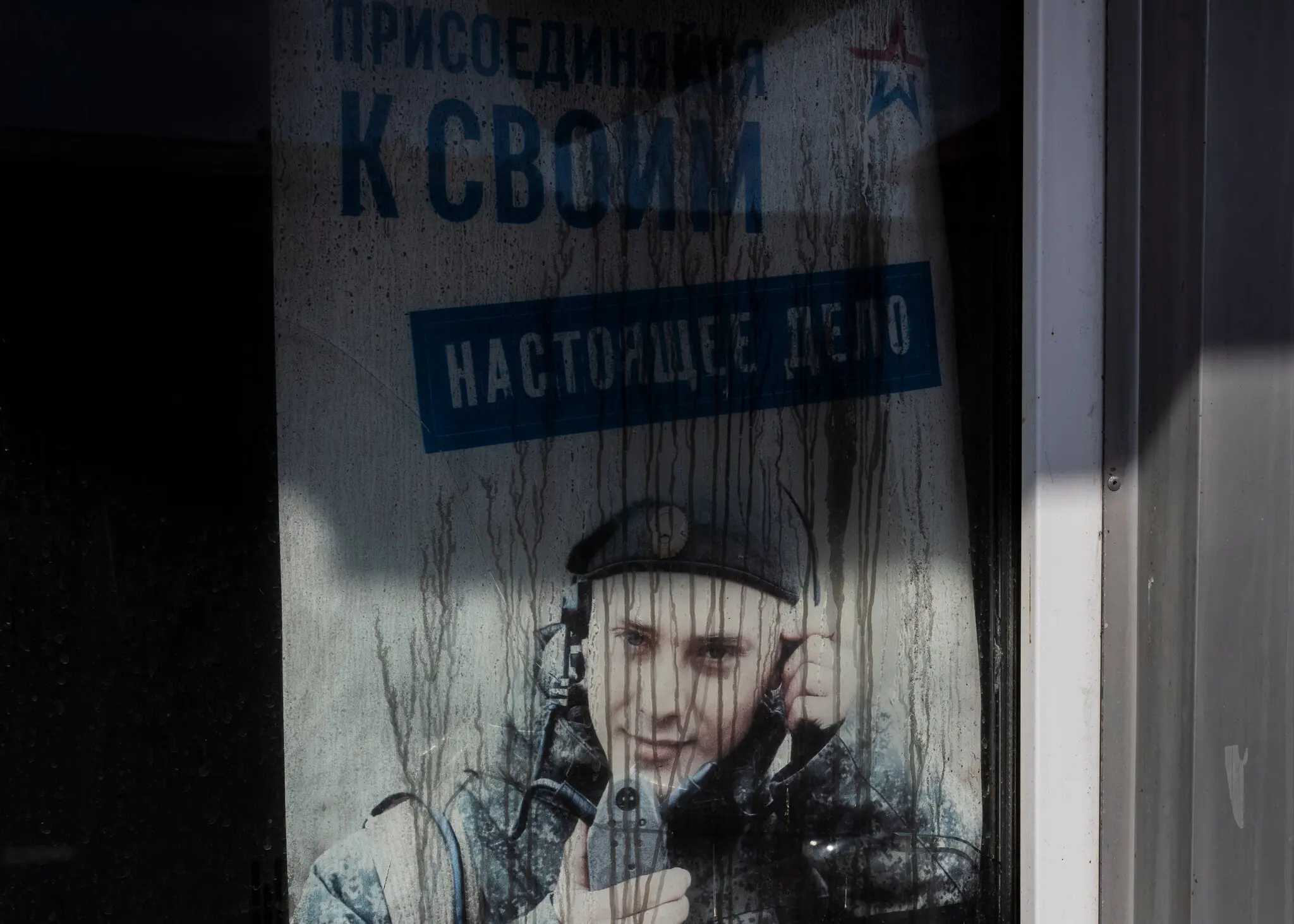 Плакат із закликом до армії в обстріляному та спаленому магазині в Грайвороні, Росія.